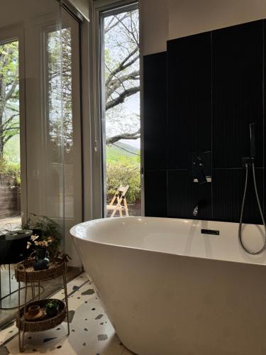 a white bath tub in a bathroom with a window at Natyra e Qetë Hideaway in Lezhë