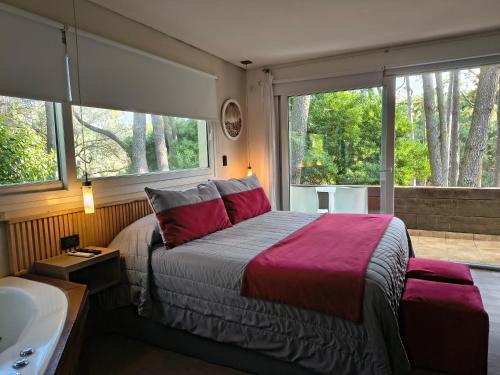 a bedroom with a bed and a sink and windows at Mizu Hotel Boutique in Mar de las Pampas