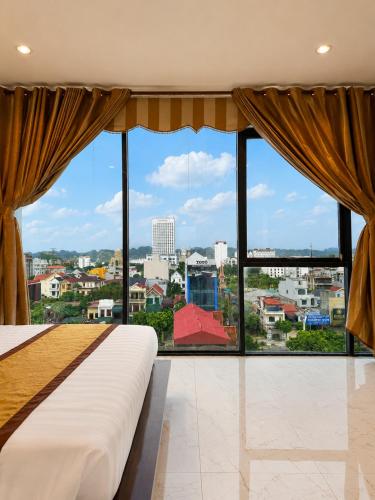 a bedroom with a large window with a view of a city at Royal ANAN Hotel in Ninh Binh