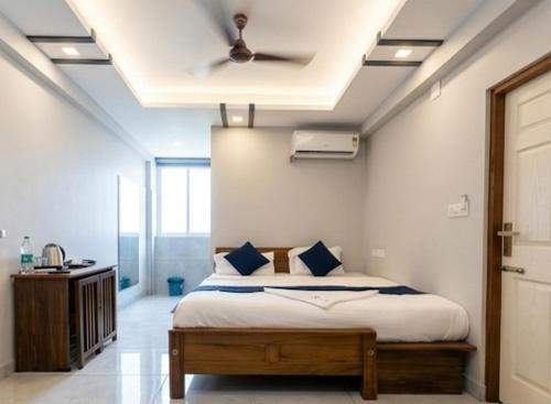 a bedroom with a bed with a ceiling fan at AIDAN RESIDENCY - AC Premium Rooms in Alwaye