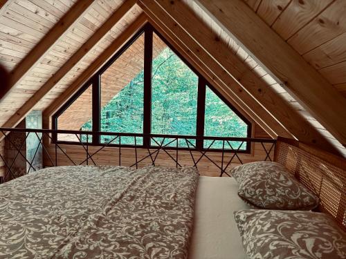 a bed in a room with a large window at Love Cabin in Slatina Varoš