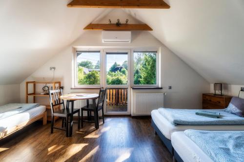 a attic room with two beds and a table and chairs at Ski House Szczyrk - Centrum in Szczyrk