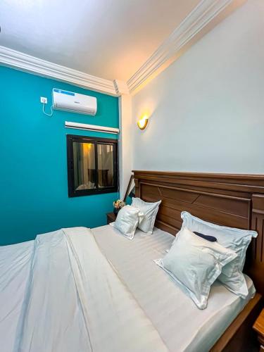 a bedroom with a large bed with blue walls at Luxury lita Résidence in Yaoundé