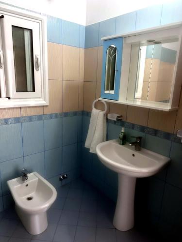 a bathroom with a sink and a toilet at Vila Merkuri - 3-Storey Villa with Sea View in Vlorë