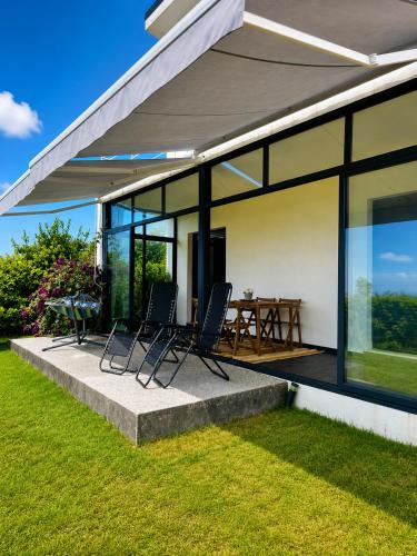 a house with a patio with chairs and a table at Blanca Mañana in Ribeira