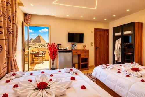 two beds in a room with a view of the pyramids at Tropitel Pyramids View Hotel in Cairo