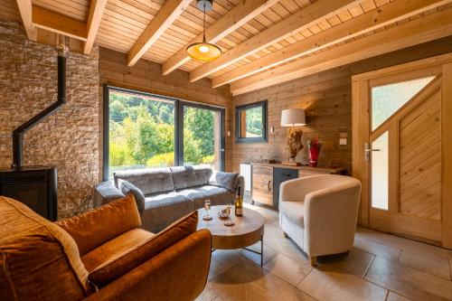 a living room with a couch and a table at "Les Reflets de la Moselotte" - Chalet premium, calme & confort, vue Montagne, proche Centre et Pistes, Parking in La Bresse