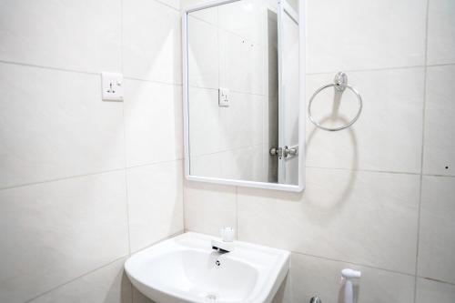 a white bathroom with a sink and a mirror at Naeco Select Pearl in Hanimaadhoo