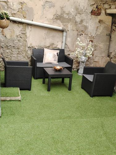 a patio with a table and chairs on grass at studio neuf in Beaumont-sur-Oise
