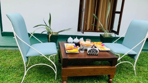 a tray of food on a table with two chairs at Mist Mountain Hiking Base in Pimbura