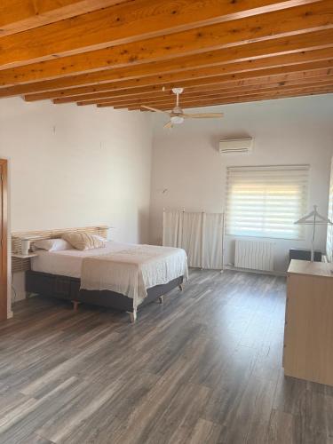 a bedroom with a bed and a wooden ceiling at Cal Piano in Palol de Rebardit
