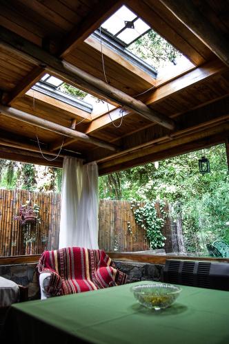 a room with a green table and a large window at Cabaña La Strega in Tandil