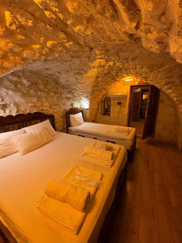 two beds in a room in a cave at Ayataç Konak Otel in Urfa