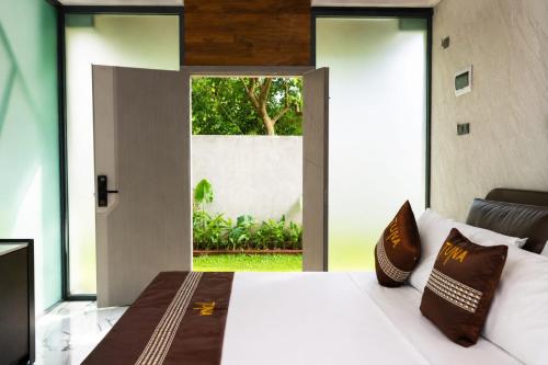a bedroom with a large bed and a large window at TUNA Hiriketiya - Luxury Resort & Pool Retreat in Hiriketiya