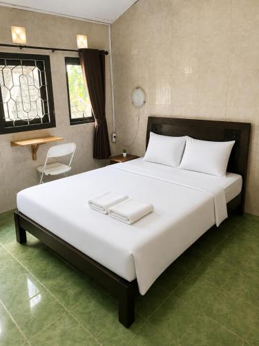 a bedroom with a large bed with two towels on it at Ambarosed Homestay in Ngaglik