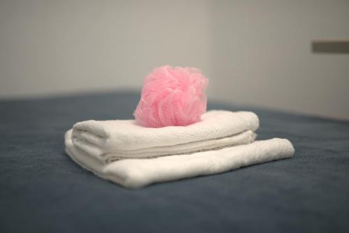 a pink ball of yarn sitting on a pile of towels at The Lemon House in Tel Aviv
