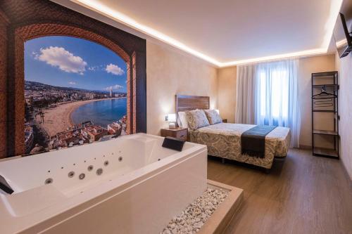 a hotel room with a large tub and a bed at Artilles Suites in Peniscola