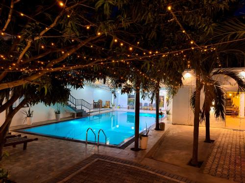 a swimming pool with christmas lights and trees at Lion Resort in Polonnaruwa