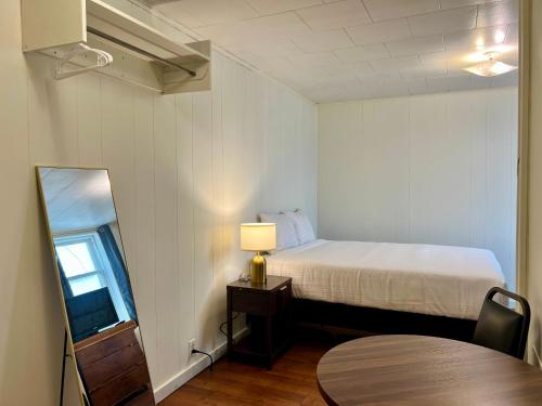 a bedroom with a bed and a table and a mirror at Grand Union Hotel in Coleman