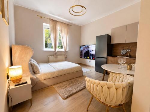 a bedroom with a bed and a table and a kitchen at Panorama Apartament in Poznań