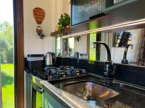 a kitchen with a sink and a stove at Cabana Flamboyant in Praia Grande