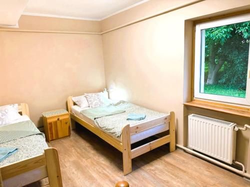 a small room with two beds and a window at Agroturystyka Różanka in Nowy Tomyśl