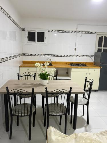 a kitchen with a wooden table and chairs in a kitchen at Résidence assia in Jijel