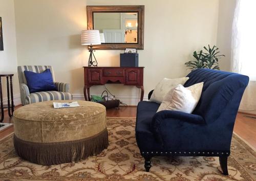 a living room with a blue chair and a ottoman at Oak Hill On Love Lane Bed and Breakfast Inn in Waynesville