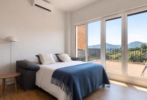 a bedroom with a bed and a large window at The Rooftop Apartments in Basauri