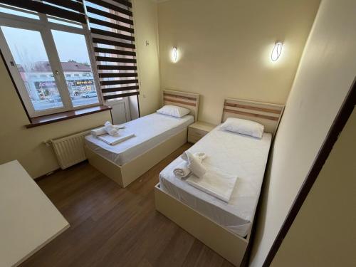 two beds in a small room with a window at Oscar Hotel Guba in Quba