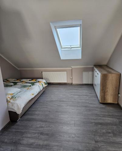 an attic bedroom with a bed and a window at Borowy Zielnik 