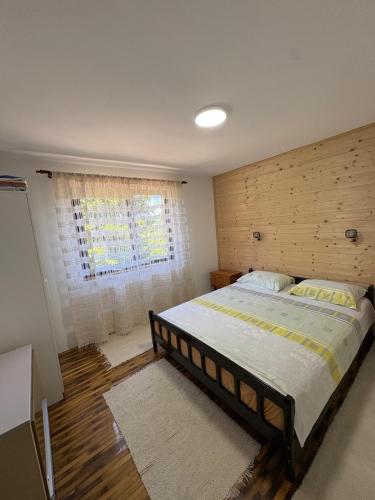 a bedroom with a large bed and a window at Apartmani Zelena jela in Šljivovica