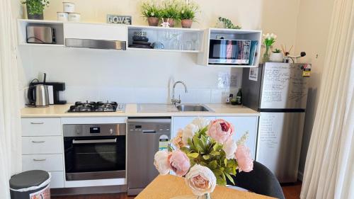 a kitchen with a sink and a table with flowers at Nature Resort Villas - Villas with a View in Cowes