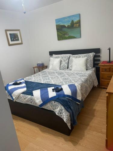 a bedroom with a bed with a blue and white blanket at Condo DidiPier in La Tuque