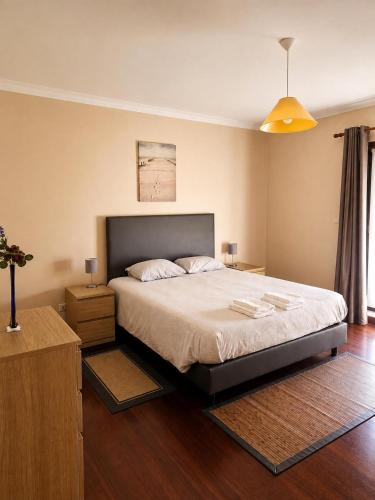 a bedroom with a large bed and a wooden floor at Casa Corujeira in Santa