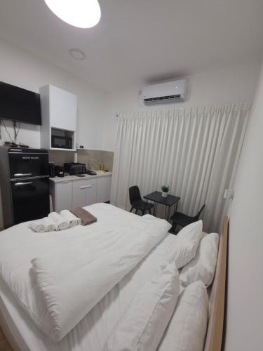 a large white bed in a room with a kitchen at Koresh 10 - Emilia suite in Jerusalem