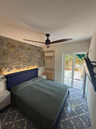 a bedroom with a bed and a stone wall at Cinquestelle Albergo del centro storico in Palinuro