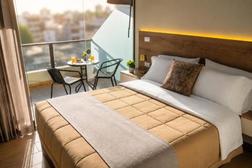 a bedroom with a bed and a balcony with a table at BRIX Hotel in Arequipa