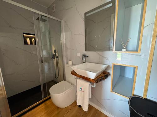 a bathroom with a sink and a shower and a toilet at Blue Whale Appartment in Horta