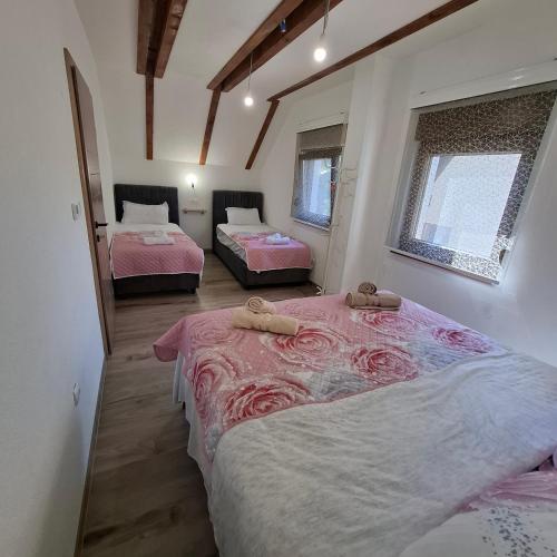 a bedroom with two beds with pink sheets at Planinska kuća Aurahill-Blidinje in Blidinje