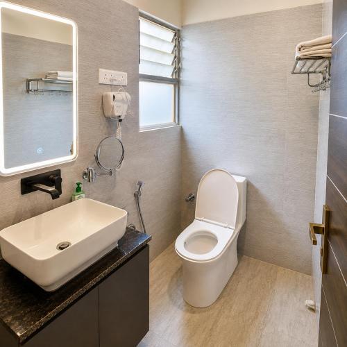 a bathroom with a white toilet and a sink at Narayan Palace- Luxury Homestay in Varanasi