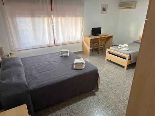 a bedroom with two beds and a desk with a computer at B&B da Antonella in Samughèo