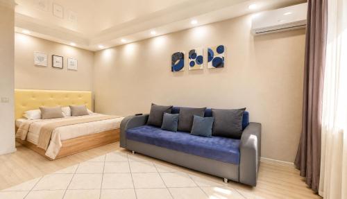 a bedroom with a bed and a blue couch at Студия Назарбаева 57 in Kokshetau