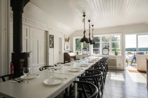 a long dining room with a long table and chairs at Historic lakeside villa - sauna, ski, boat, 20 guests in Sunnansjö