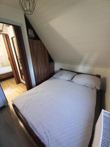 a bed with two pillows on it in a room at Amelia Domek letniskowy in Mechelinki