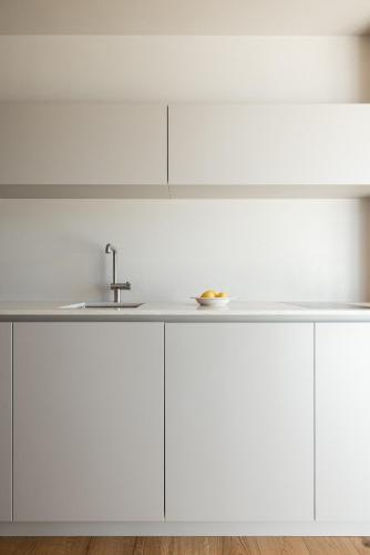 a kitchen with white cabinets and a sink at Essa Suites - NEW in Caldaro