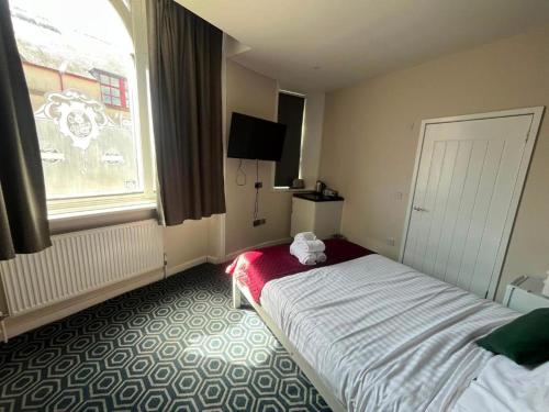 a hotel room with a bed and a window at Homesly Guest Rooms, Comfortable En-suite Guest Rooms with Free Parking and Self Check-in in Berwick-Upon-Tweed