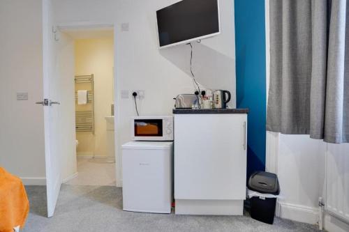 a living room with a tv on a wall at Homesly Guest Rooms, Comfortable En-suite Guest Rooms with Free Parking and Self Check-in in Berwick-Upon-Tweed