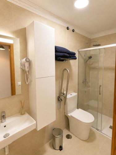 a bathroom with a toilet and a sink and a shower at Roca Mogán in Puerto de Mogán