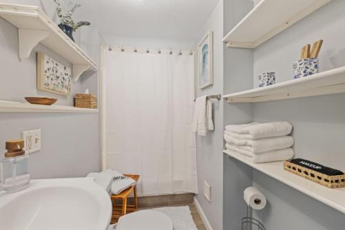 a white bathroom with a white toilet and towels at Dog-Friendly Retreat, Fire Pit, Lakes Region in Gilmanton